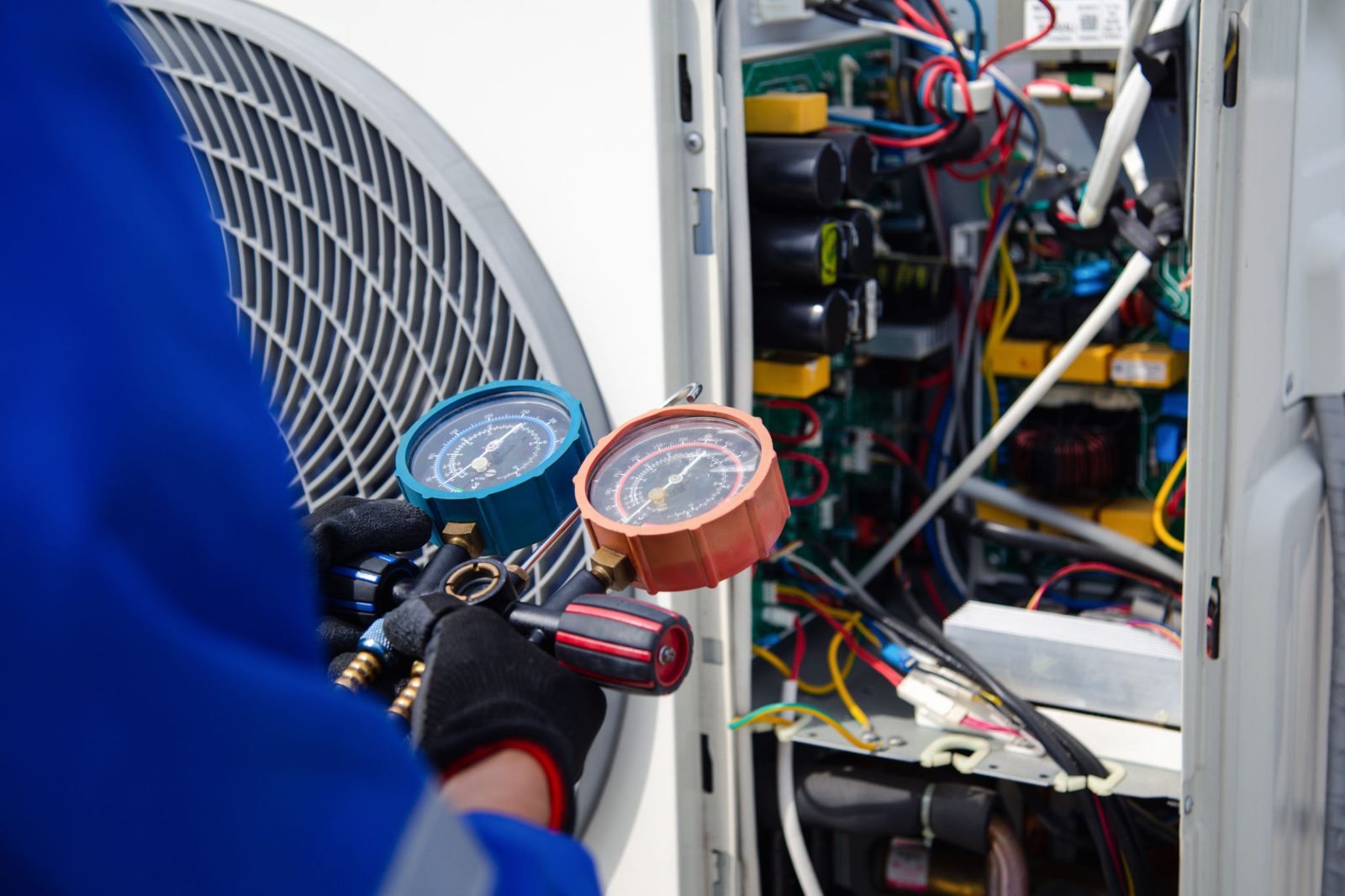 Refrigerant gauges connected to an air conditioner during a tune-up